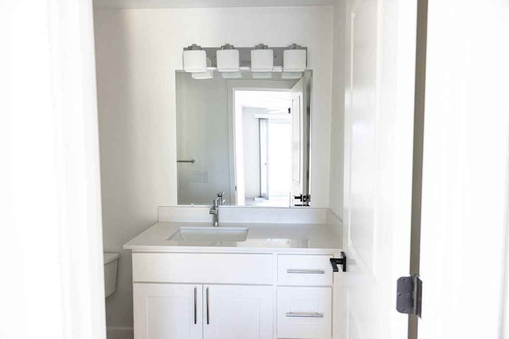 a white bathroom with a sink and a mirror