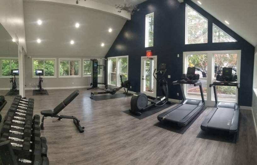 a gym with a lot of equipment and windows