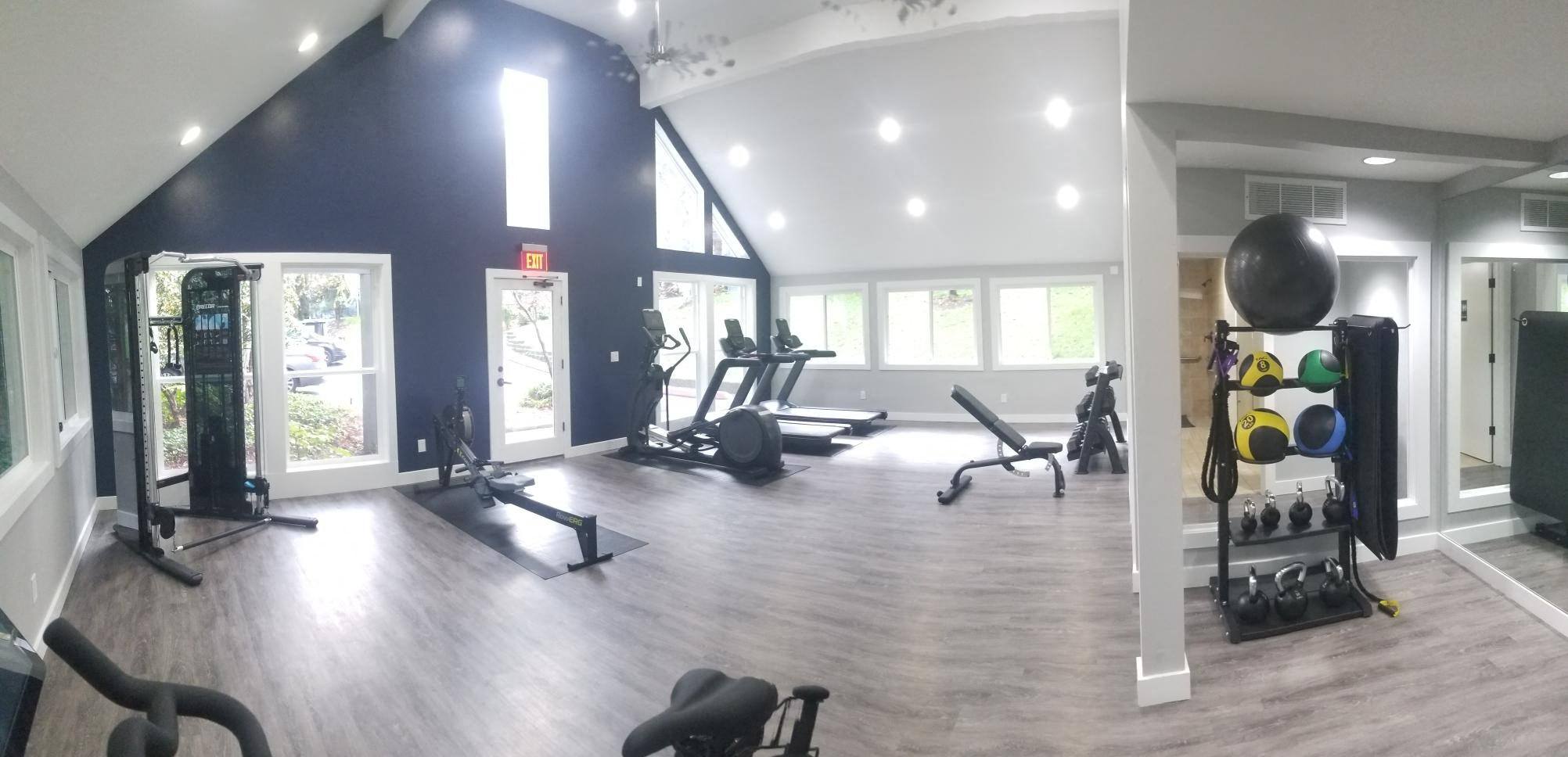 a gym with exercise equipment and windows in a building