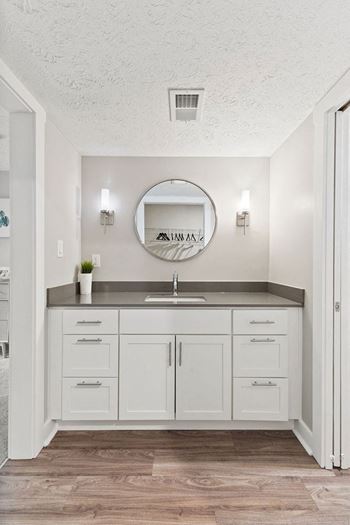 a white bathroom with a sink and a mirror