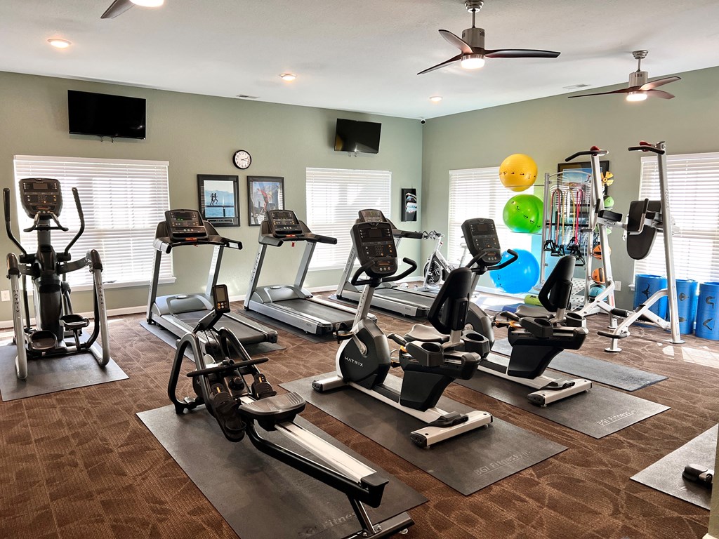 a spacious fitness room with treadmills and other exercise equipment