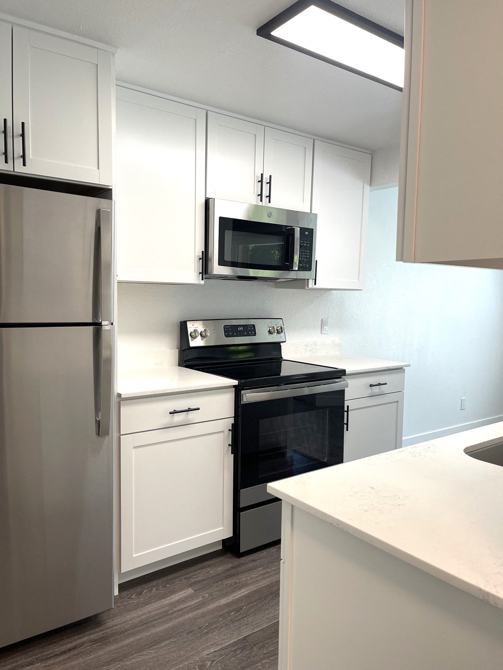 a kitchen with white cabinets and a stove and a microwave