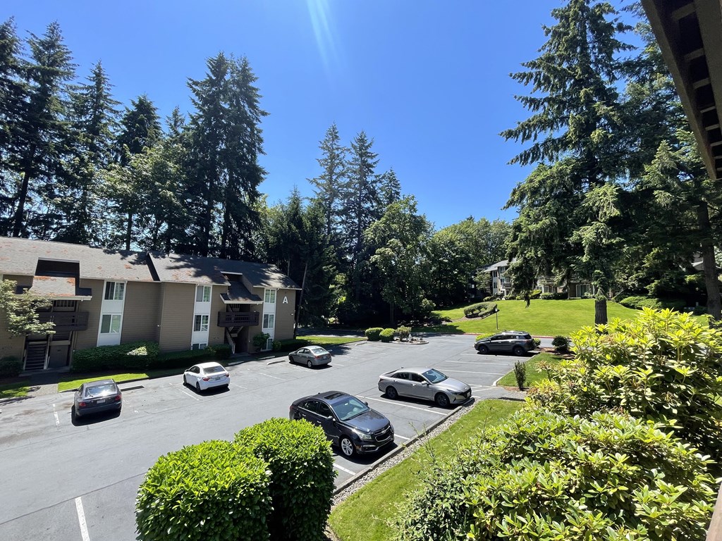 an aerial view of a parking lot with cars in front of houses