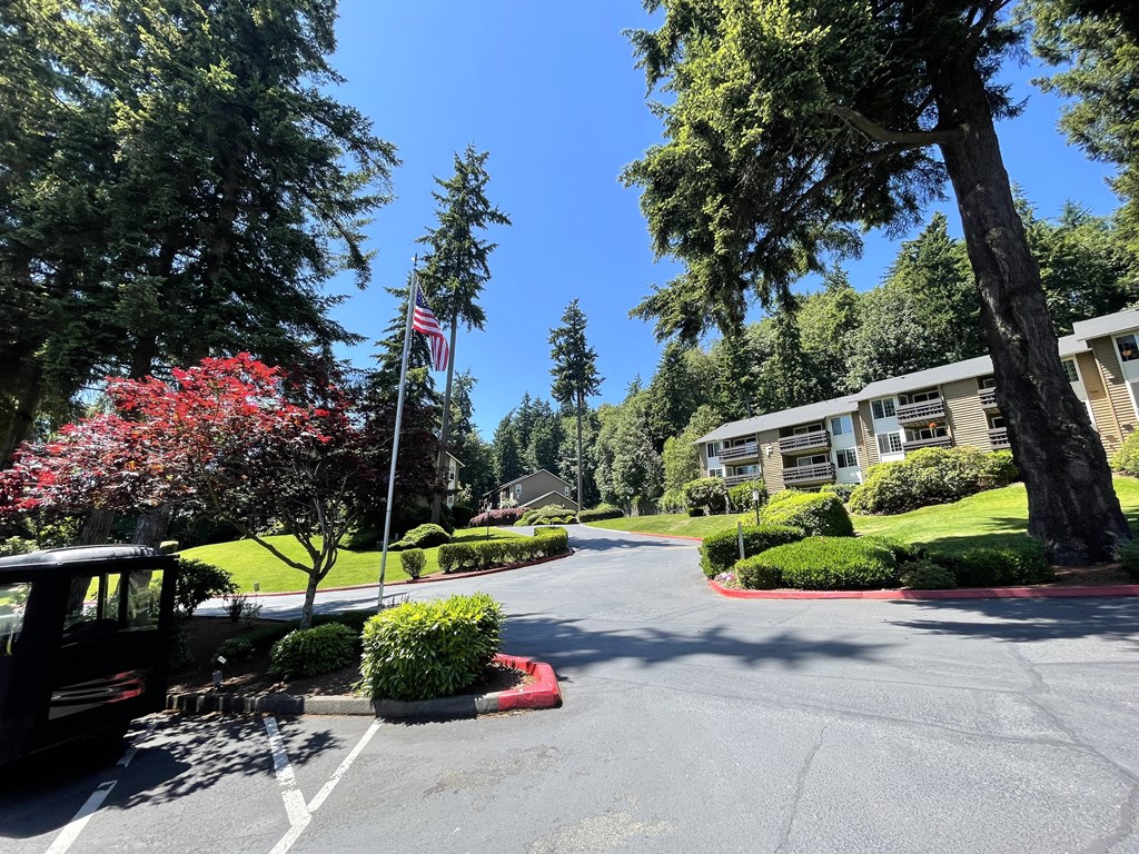 a parking lot with a flag in front of an apartment building