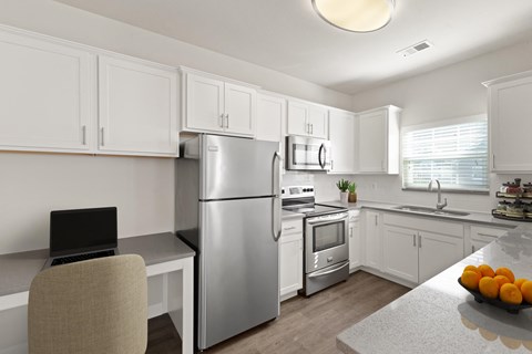 a kitchen with white cabinets and stainless steel appliances