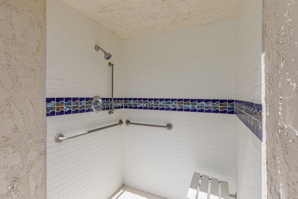 a walk in shower with white walls and blue tile at La Serena, San Diego, California