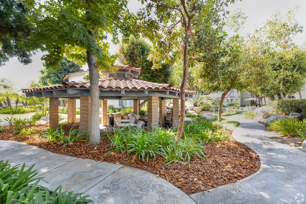 a stone gazebo sits in the middle of a garden