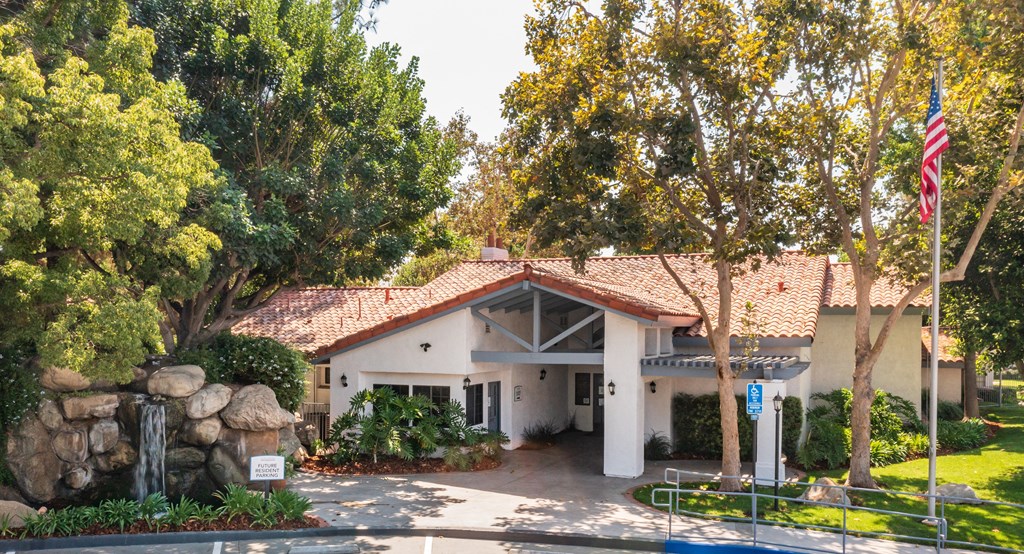a building with a red tile roof and a pool in front of it