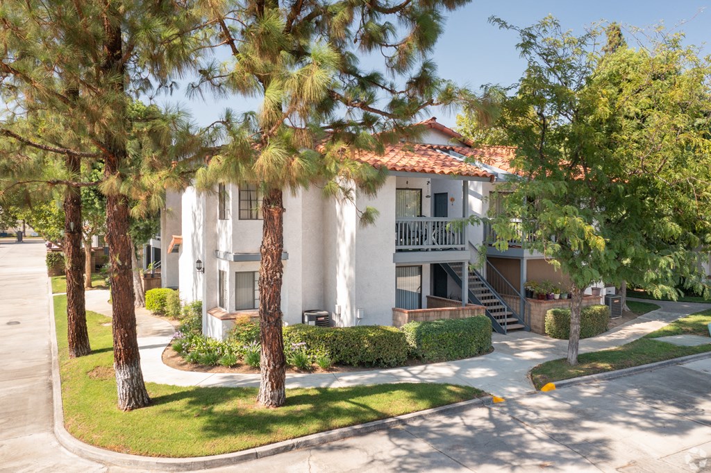 a building with a staircase and trees in front of it