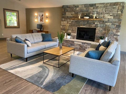 a living room with couches and a stone fireplace