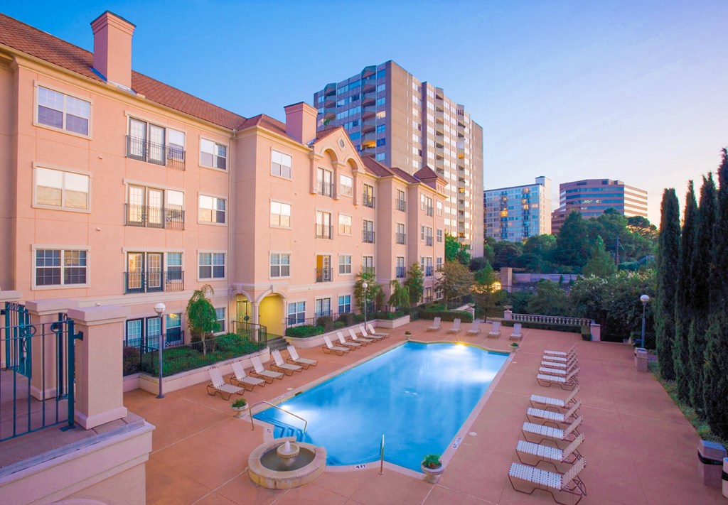 Sparkling pool with lounge chairs at The Villas At Katy Trail Apartments in Dallas, TX offers studios, 1,2 and 3 bedroom apartment homes!