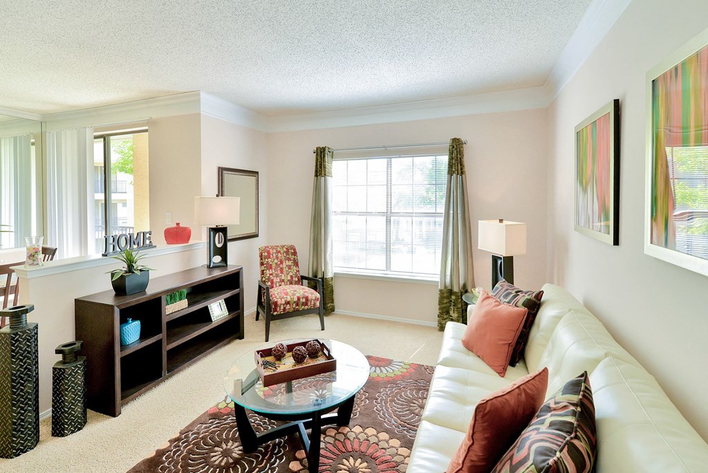 Living room with couch table and chair with painting on wall and window