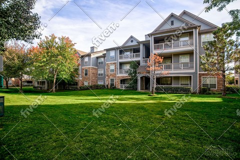 A large grassy area in front of apartment buildings.
