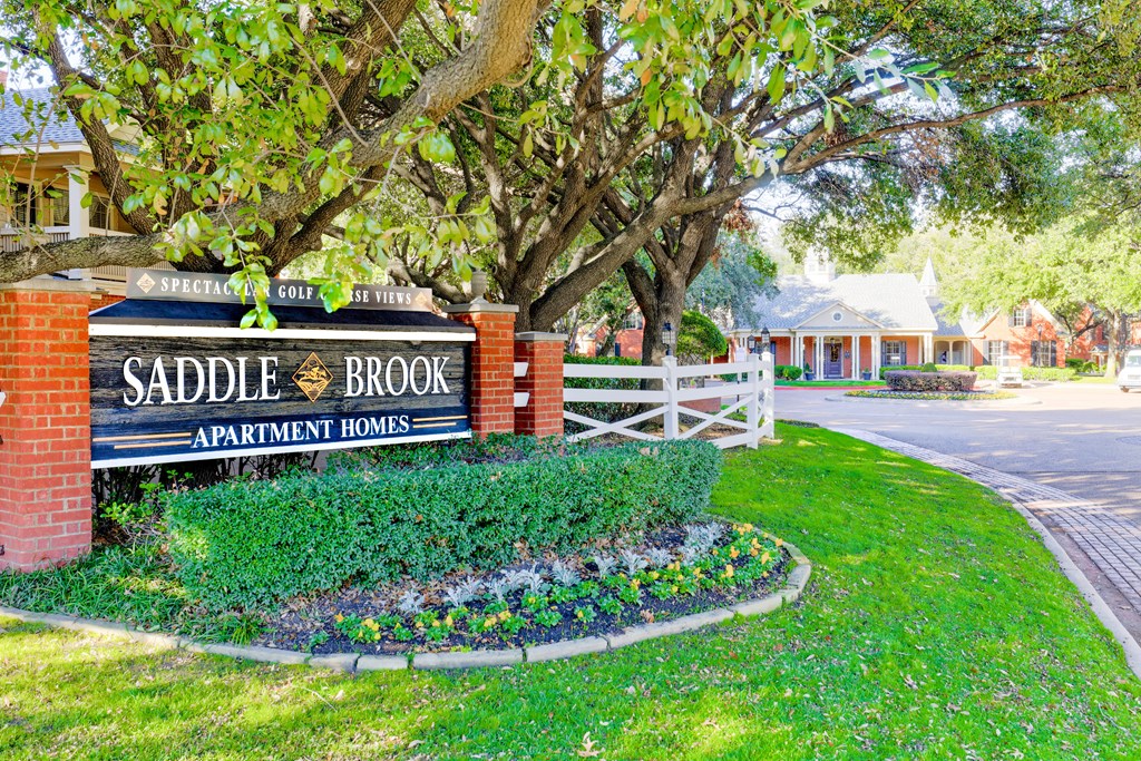 Property entrance with grassy lawn at SaddleBrook Apartments, Dallas