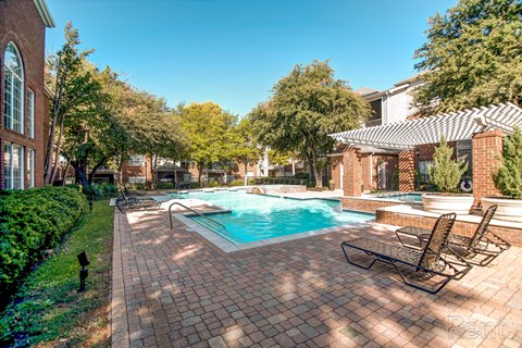 A backyard with a pool and patio furniture.