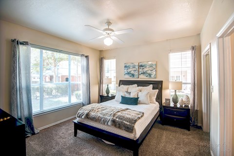 A bedroom with a large bed and a piano.