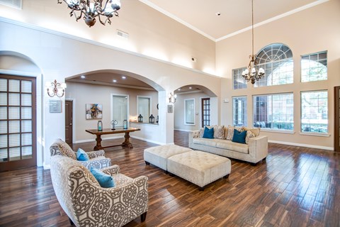A living room with a white couch and a patterned chair.