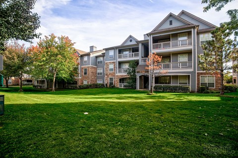 Apartment complex with green grass in front.