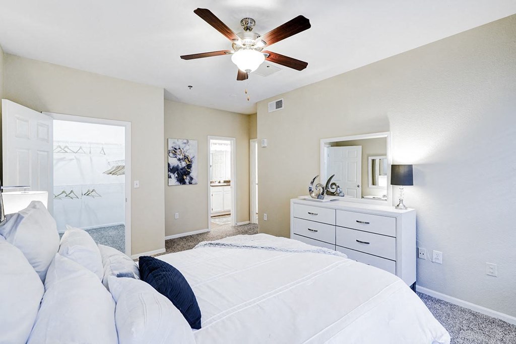 Interior bedroom with white walls and white dresser at Villas at Katy Trail Apartments, Texas
