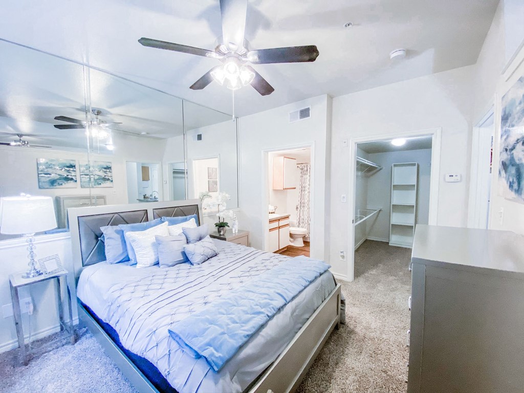 Bedroom with large mirrors and ceiling fan at Tuscany Square, Dallas
