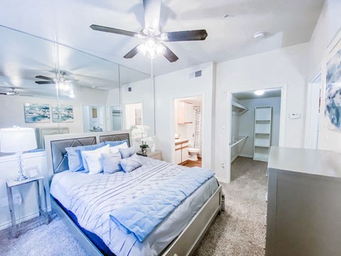 a bedroom with a large bed and a ceiling fan