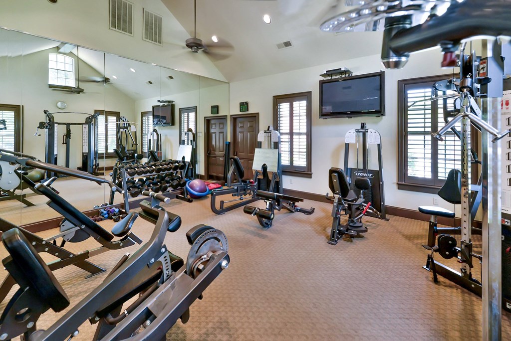 Modern fitness center with brown floor at SaddleBrook Apartments, Dallas, TX