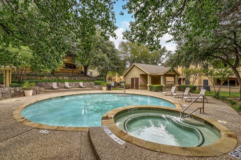 A hot tub sits in the middle of a stone patio.