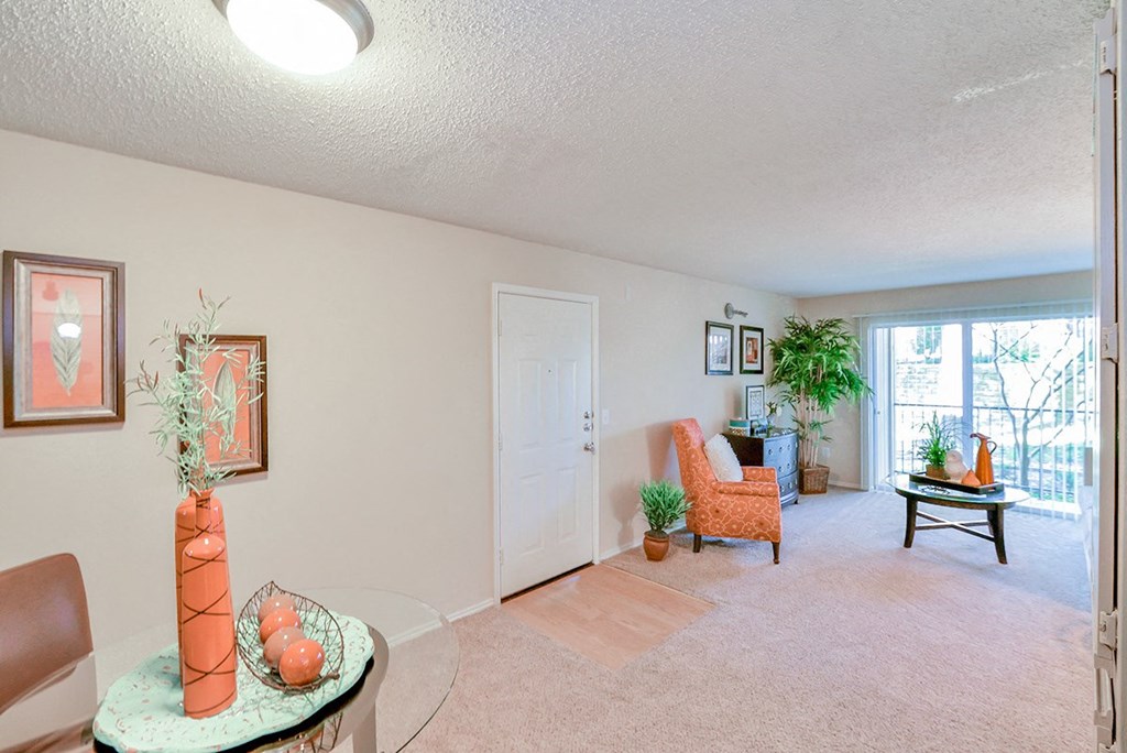 Spacious  living room with a chair and a table and a window