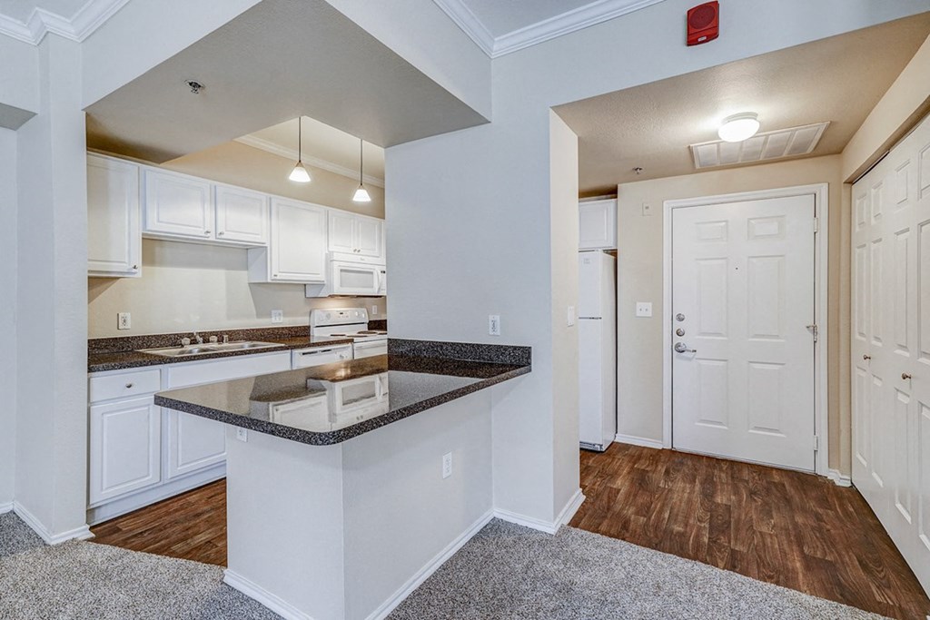 a kitchen with white cabinets and a counter top at Villas at Katy Trail Apartments, Dallas
