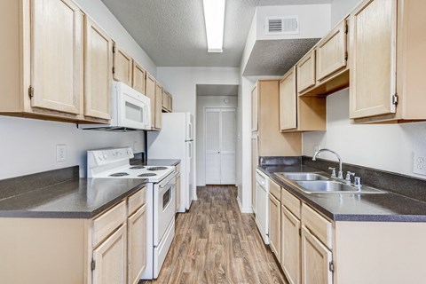 A kitchen with wooden cabinets and white appliances.