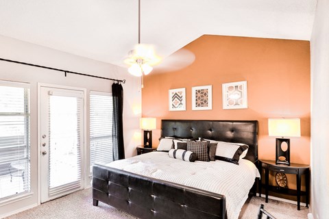 a bedroom with a large bed and a sliding glass door