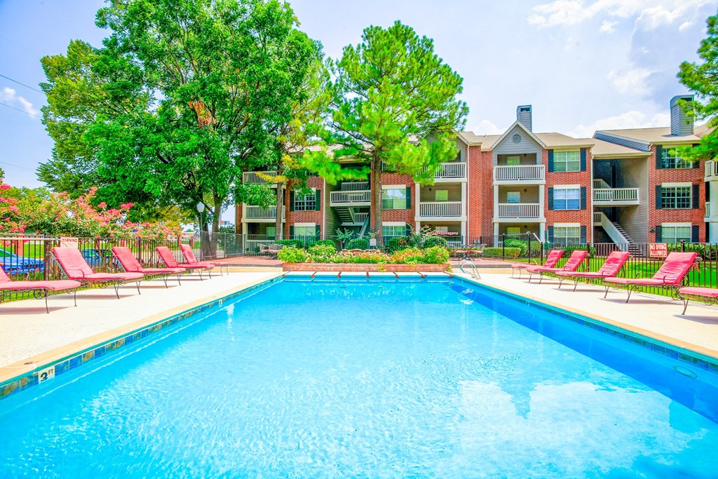 Outdoor swimming pool with lounge chairs and lush landscaping at Greenbriar Apartments, Tulsa, Oklahoma