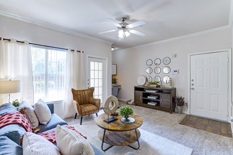 A living room with a brown chair and a white ceiling fan.