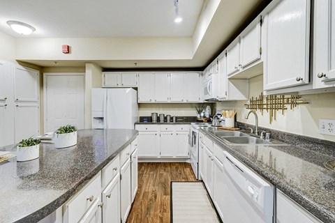 a kitchen with white cabinets and granite counter tops