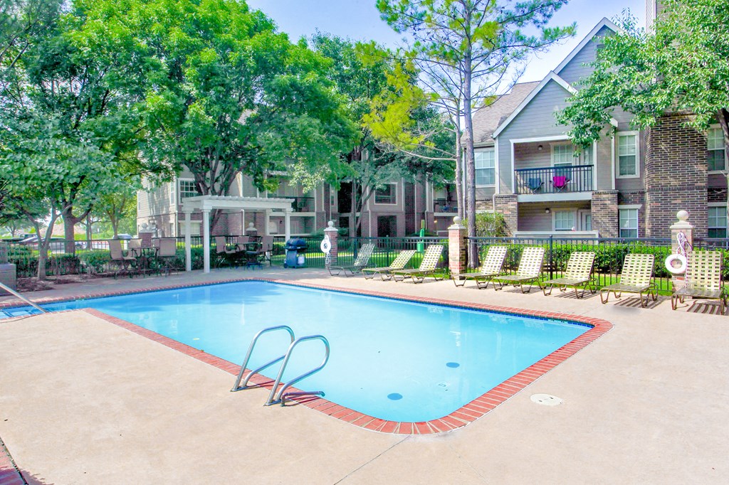 Resort style pool with lounge chairs at Riverside Park Apartments, Tulsa, OK