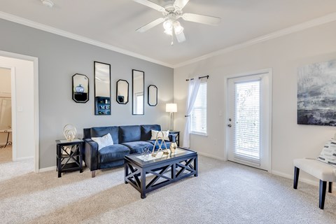 A living room with a blue couch and a white coffee table.