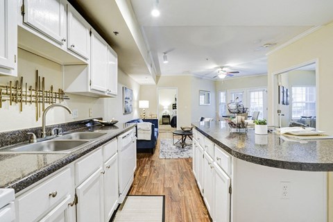 a large kitchen with white cabinets and granite counter tops