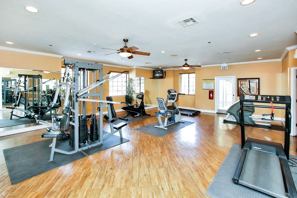 Gym with equipment including weights and cardio machines at Pavilions at Pantano Apartments, Tucson, Arizona