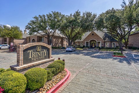 A sign that says Trinity Square is in front of a building.
