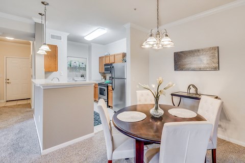 A modern kitchen with a dining table set for two.