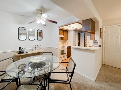 an open kitchen and dining room with a glass table and chairs