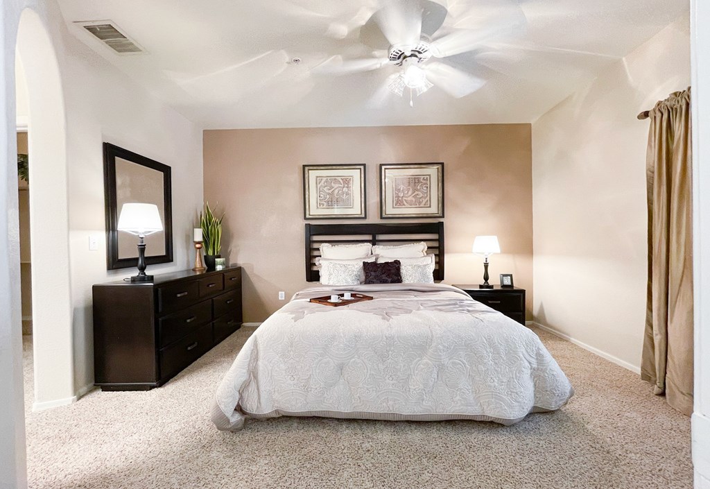 Interior view of large bedroom with tan accent wall  at Ventana, Scottsdale, AZ