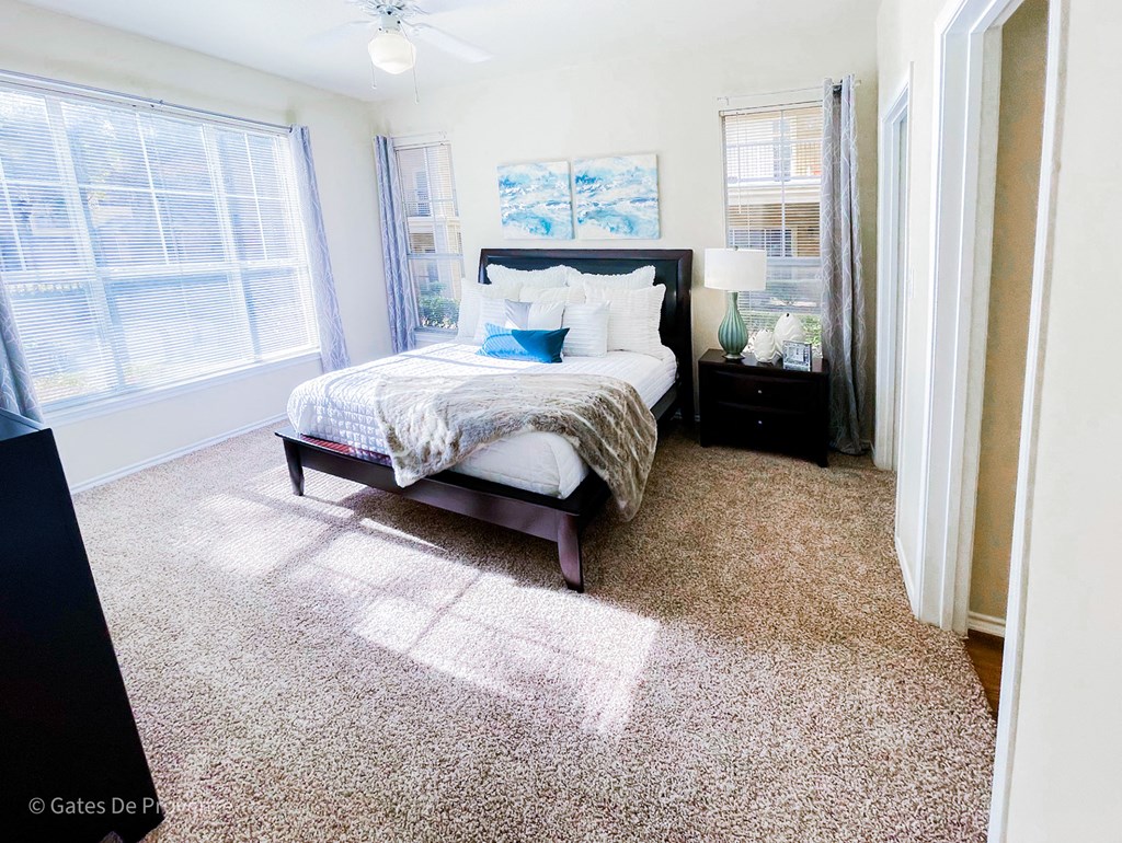 Interior bedroom with beige carpeting and white walls at Gates de Provence Apartments, Dallas, Texas
