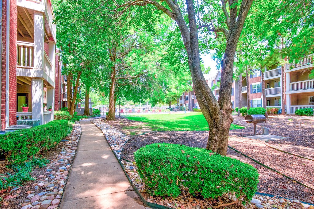 Exterior of apartment with tree-lined view and walking paths at Greenbriar Apartments, Tulsa, 74136