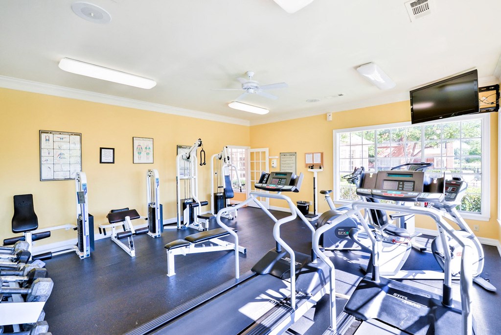 Fitness center with yellow walls at Turnberry Isle Apartment Homes, Texas