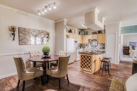 a living room and kitchen with a dining table and chairs