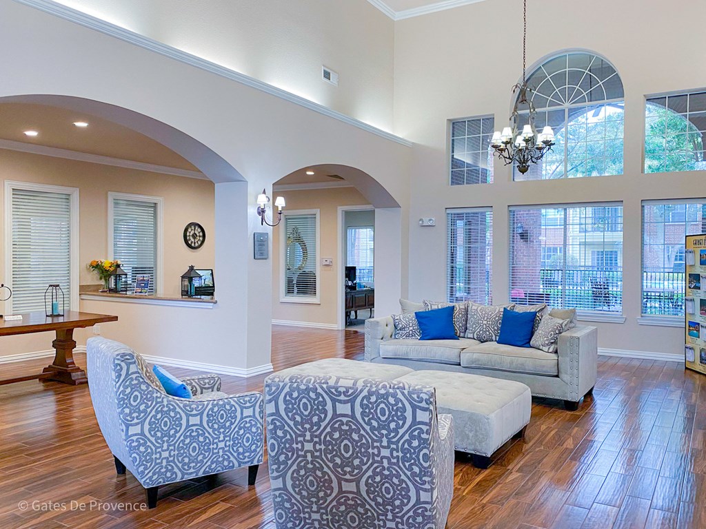 Clubhouse living room with blue chairs and sofa at Gates de Provence Apartments, Dallas, TX