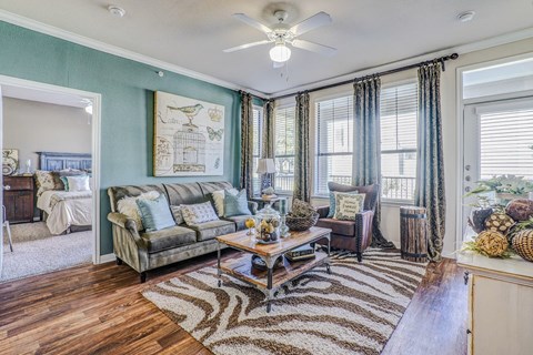 a living room with blue walls and a ceiling fan