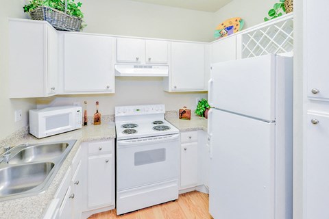 a kitchen with white appliances and white cabinets