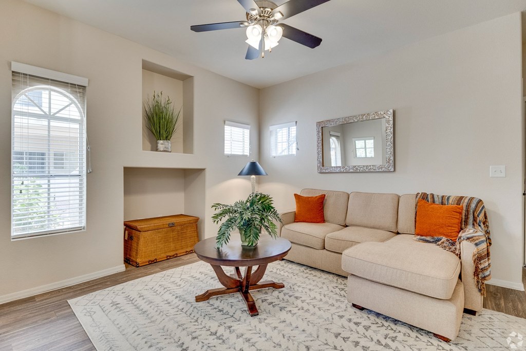 A living room with a beige couch, a wooden coffee table, and a ceiling fan. at Ventana, Scottsdale, Arizona